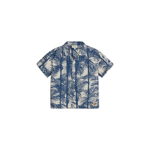 A short-sleeve, button-up shirt features a blue palm tree pattern on a beige background. It includes a small brown patch logo at the lower right corner.