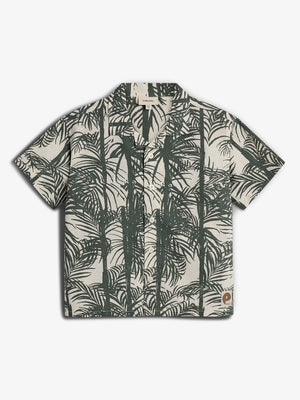 Short-sleeved shirt features a tropical palm leaf print in dark green on a light background. It has buttons down the front and a collar, set against a plain backdrop.