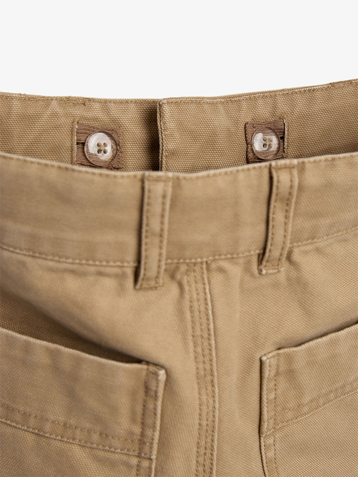 Tan pants with two buttons on the inside waistband and visible belt loops. The pants feature sturdy stitching and two front patch pockets, shown against a plain white background.