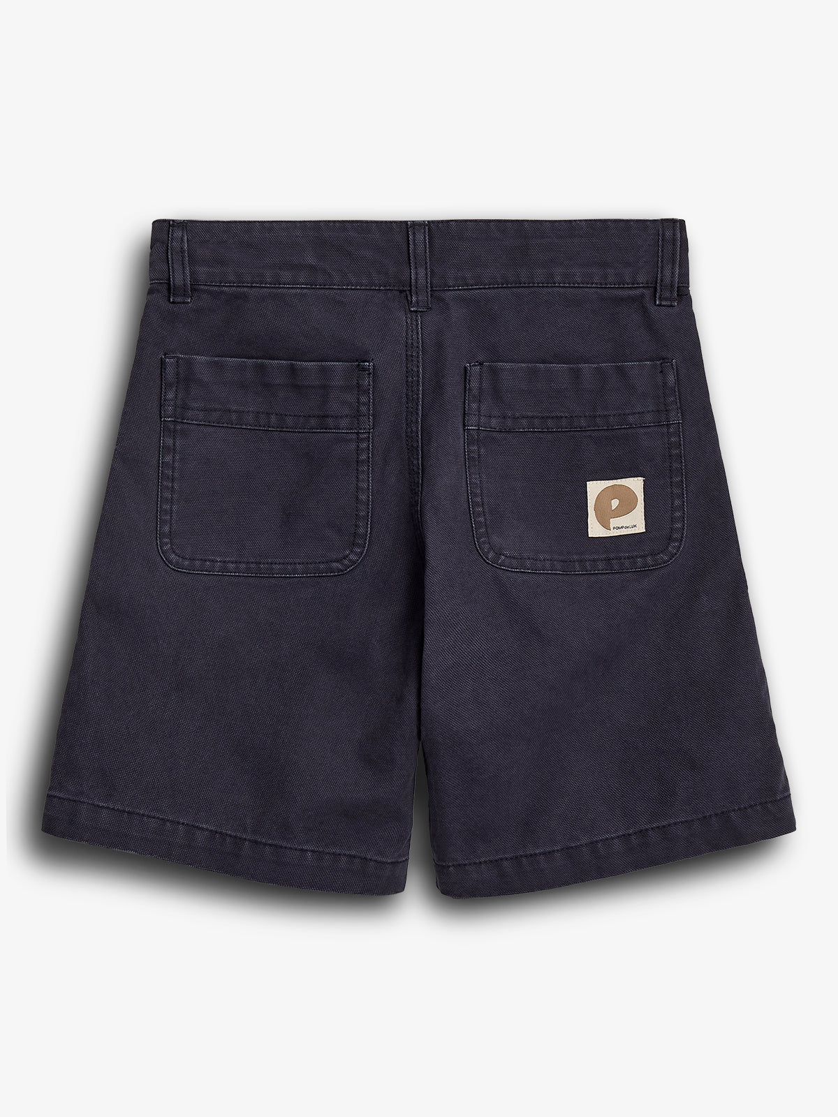 Dark shorts are displayed flat with two back pockets. A small beige patch with a logo is on the right pocket. The background is plain white.