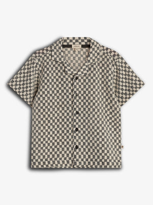 Short-sleeved shirt with a black and white checkered pattern, featuring black buttons and a collar, displayed against a plain white background.