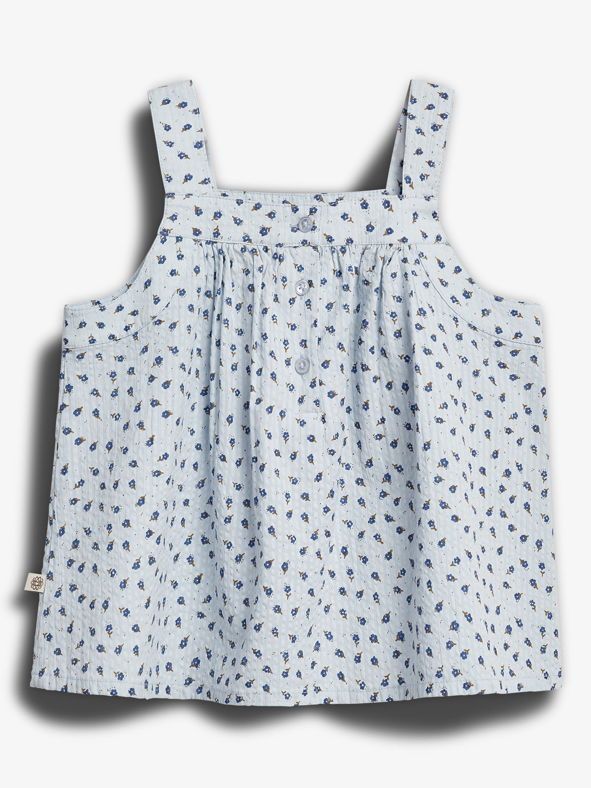 A light blue sleeveless top with thin straps features small blue floral patterns and buttons down the front, set against a plain white background.