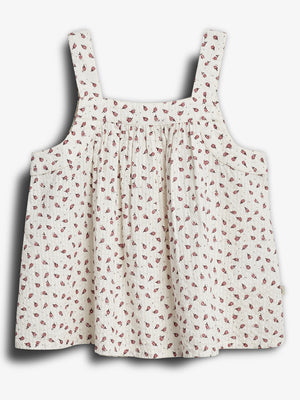 Sleeveless, floral-patterned dress with thick straps hangs against a plain backdrop. The fabric is light-colored with small, red floral designs scattered throughout.