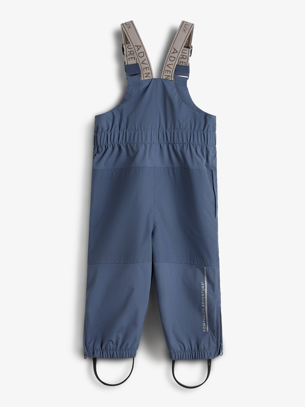 Blue children's overalls with elastic ankle bands and adjustable beige shoulder straps reading "ADVENTURE." The word "POMPdeLUX ADVENTURE" is written vertically on the right leg. Set against a white background.