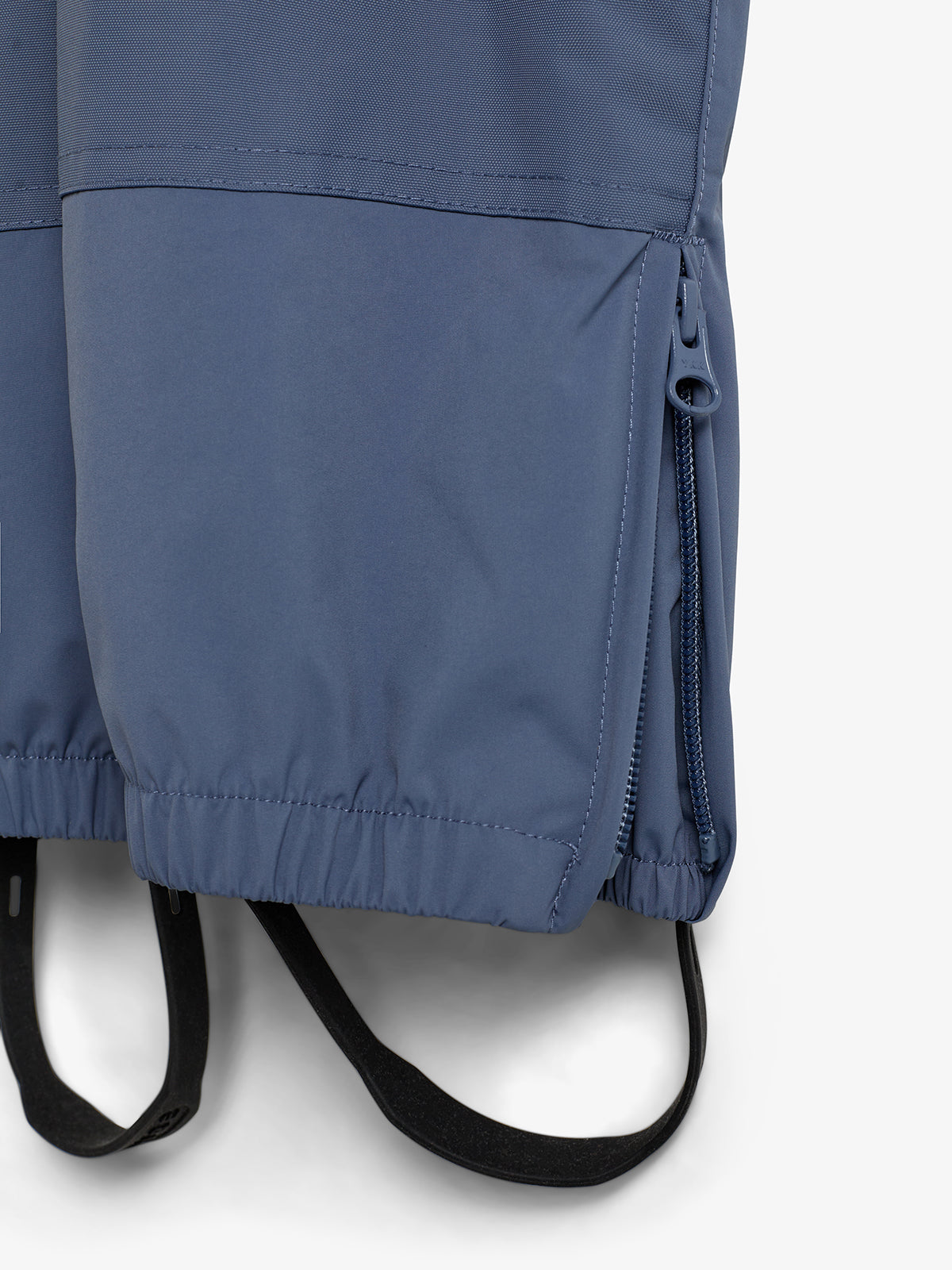 A blue garment features a closed zipper on the right side and elasticized cuffs. Black adjustable straps extend from the bottom, set against a plain white background.