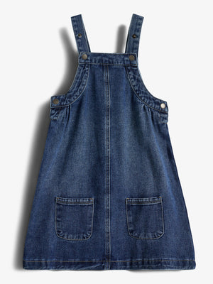 A blue denim pinafore dress with two straps and front pockets, laid flat against a white background.