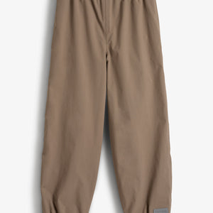 Brown pants with elastic waist and cuffs are laid flat on a white background. A small patch on the lower right leg reads "Porte à Clic."