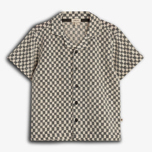 Short-sleeved shirt with a black and white checkered pattern, featuring black buttons and a collar, displayed against a plain white background.