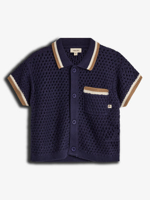 A navy blue, short-sleeved, knitted cardigan with button closure and striped collar and sleeves, features a pocket with beige and white accents. Label reads "pimaluLino." Background is plain white.